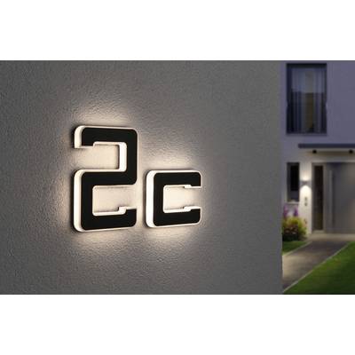 House number '2c' on an illuminated wall. In the background, part of a house with an entrance is visible.