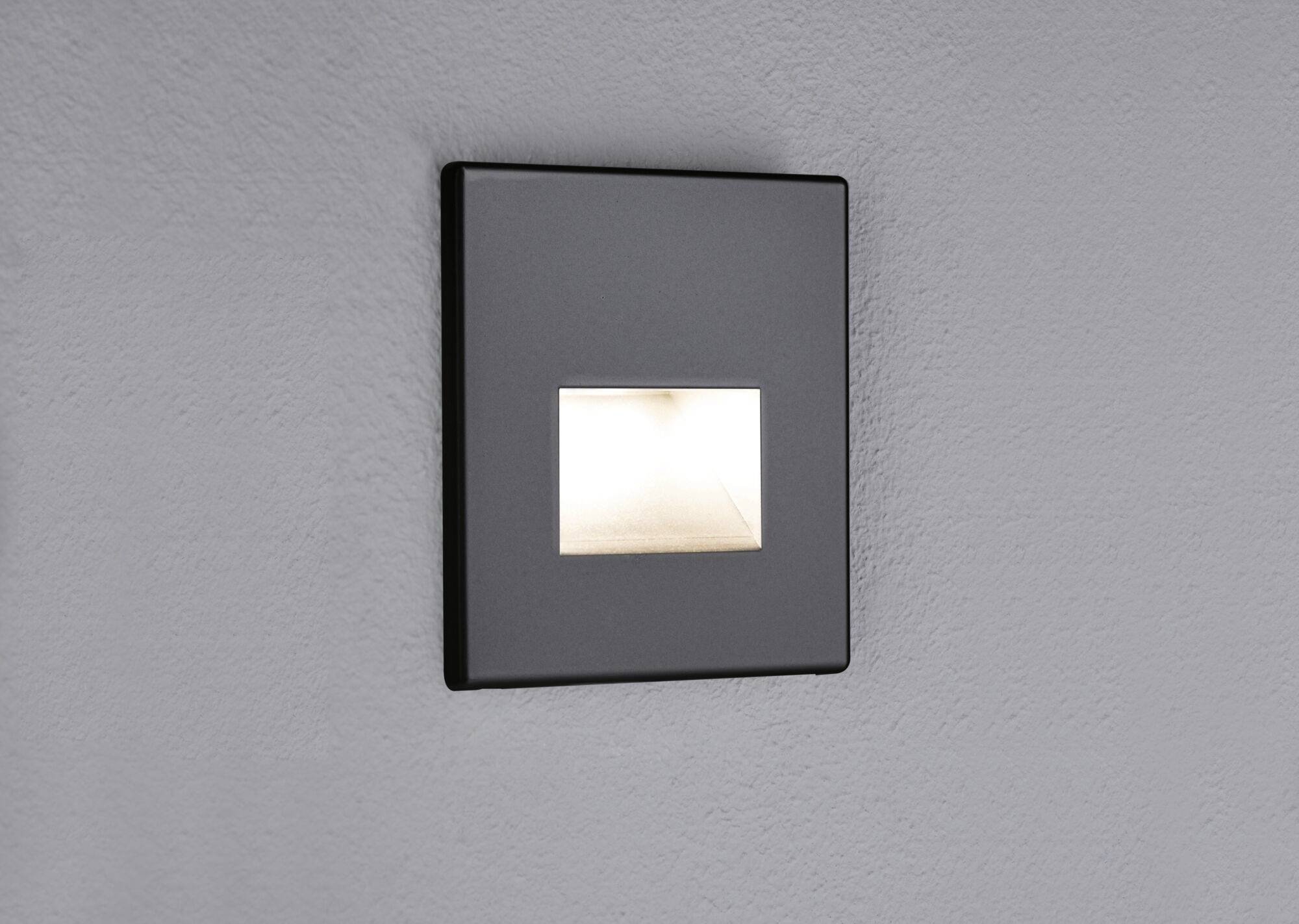 Wall-mounted lamp with a rectangular light field against a grey wall, subtle design for indirect lighting.