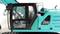 Excavator cabin interior, left side, model number 'G101H' on a turquoise dashboard.