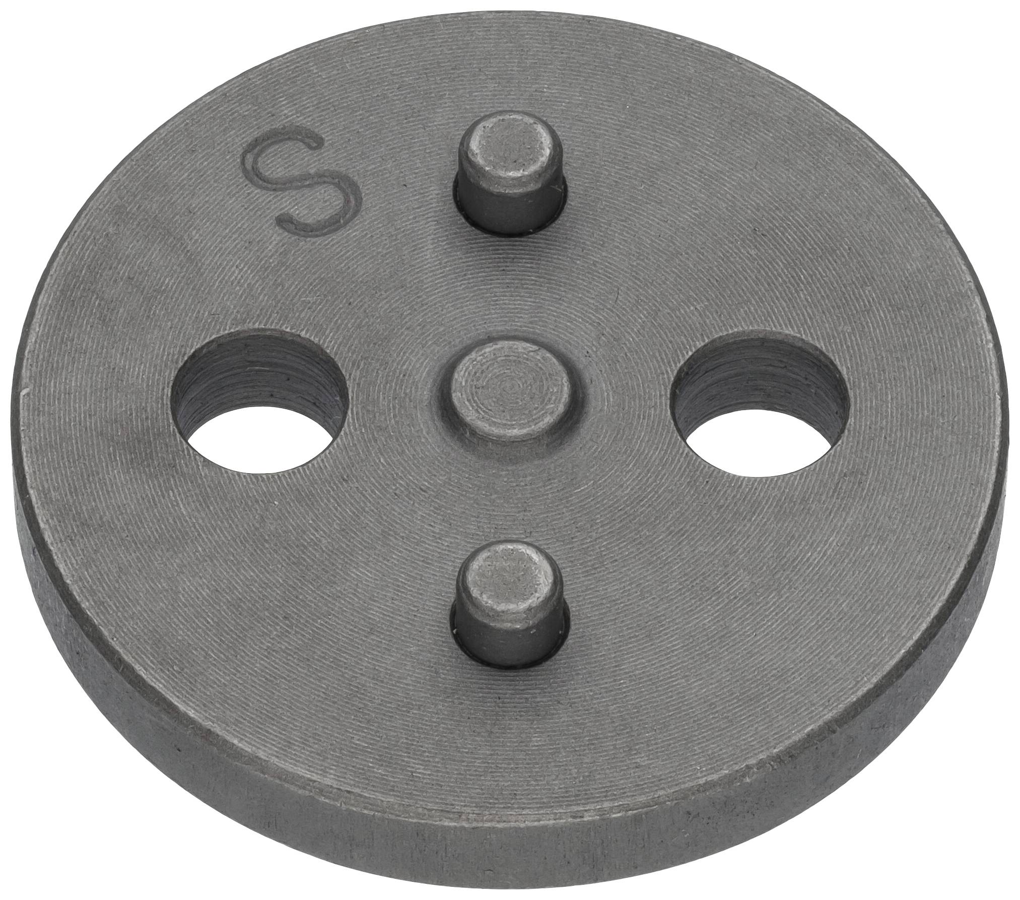 Round, grey metal disc with four raised dots and two holes; in the top left, one can see the letter 'S'.