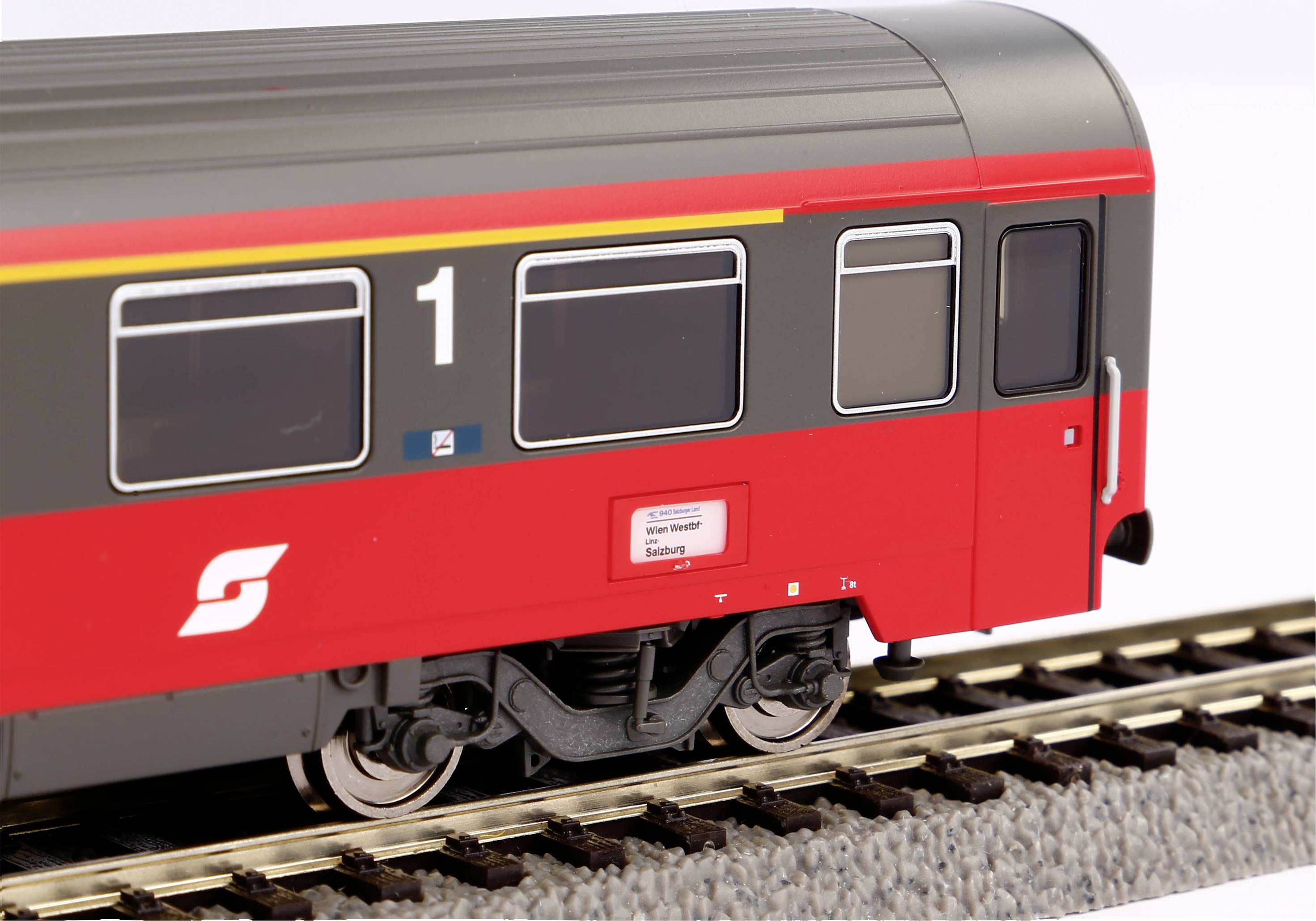 Red and grey train model of the Austrian railway on a track.