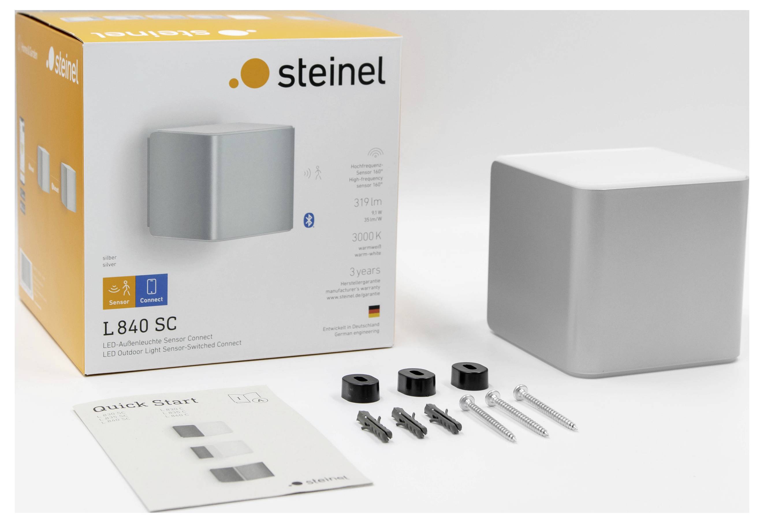 Steinel L 840 SC LED wall light kit with box, square gray lamp, quick-start guide, and mounting screws on a white background.