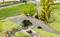 A miniature model shows a bridge over a small stream. A figure stands on the bridge with a fishing rod, another sits beside it.