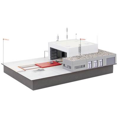 Scale model of a modern industrial building complex with loading area and office wing, antennae on the roof.