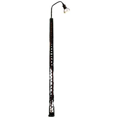 An unusual street lamp with an artfully crafted, perforated metal shaft and an angled lampshade on top.