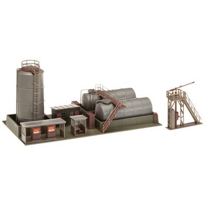 Model of an industrial plant with multiple tanks, pipes, and buildings. Two main tanks with a staircase, adjacent smaller structures.