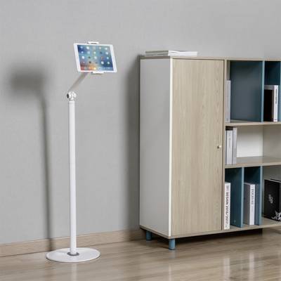 Tablet on a stand next to a bookshelf with books and folders in a bright room.