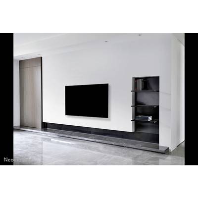 Living room with modern design. A large flatscreen television is mounted on a white wall with a black shelving unit beside it.