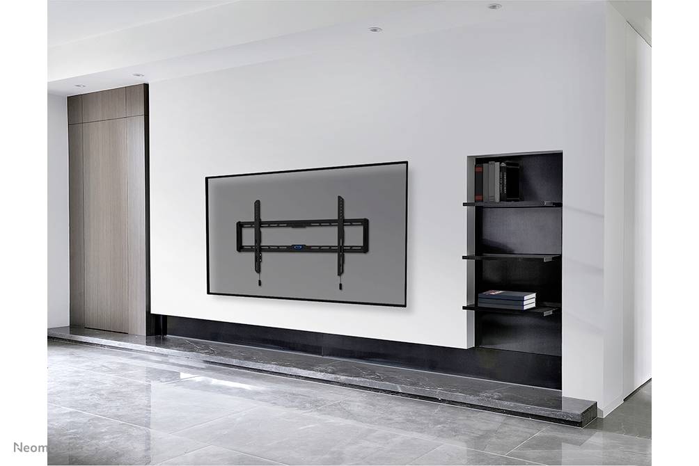 A modern, minimalist space with a large, wall-mounted, black flatscreen television and a plain shelf to the right.