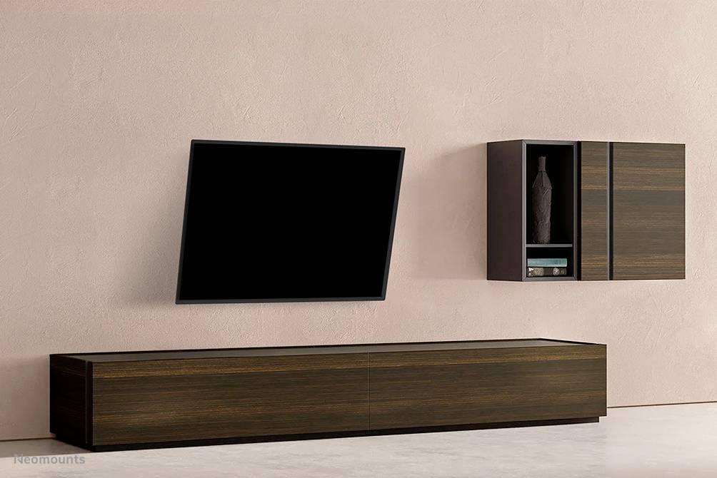 A modern living room with a wall-mounted television, a wooden TV cabinet and a wall shelf with a vase.