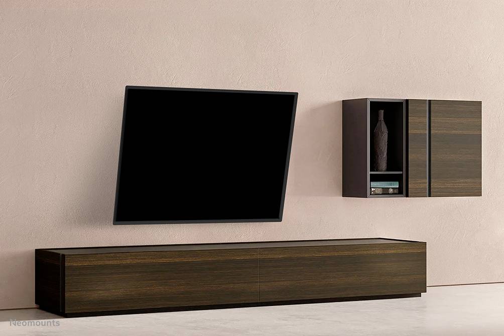 A contemporary living room wardrobe with a mounted black surface on the wall and a light wooden wall-mounted cabinet with vases.
