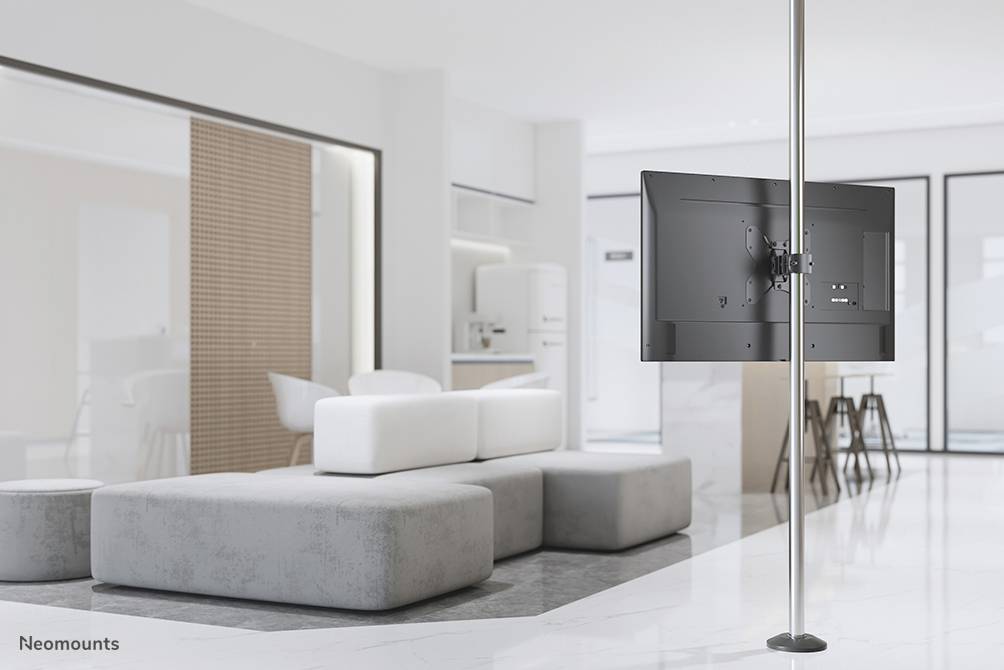 Bright, modern living room with grey and white furniture. A flat-screen television is mounted on a vertical pole.