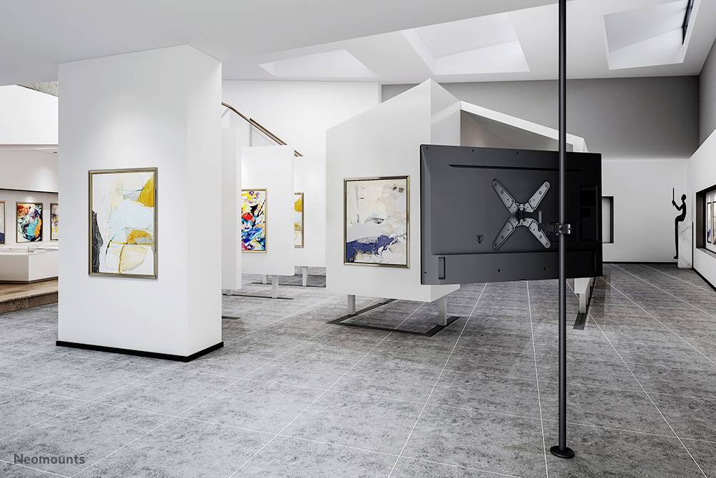 A contemporary gallery space with abstract art on white walls. Bright ceilings and grey flooring define the minimalist design.