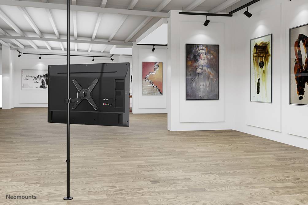 A contemporary gallery space with abstract artwork on white walls, a clean wooden floor, and a television mounted on a pole.
