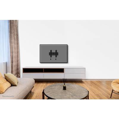 Flat television mounted on the wall in a modern living room with sofa, table and rug.