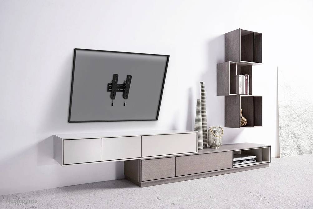 Modern living area with a floating low sideboard and a wall-mounted television at an angle. Wall shelves on the right side.
