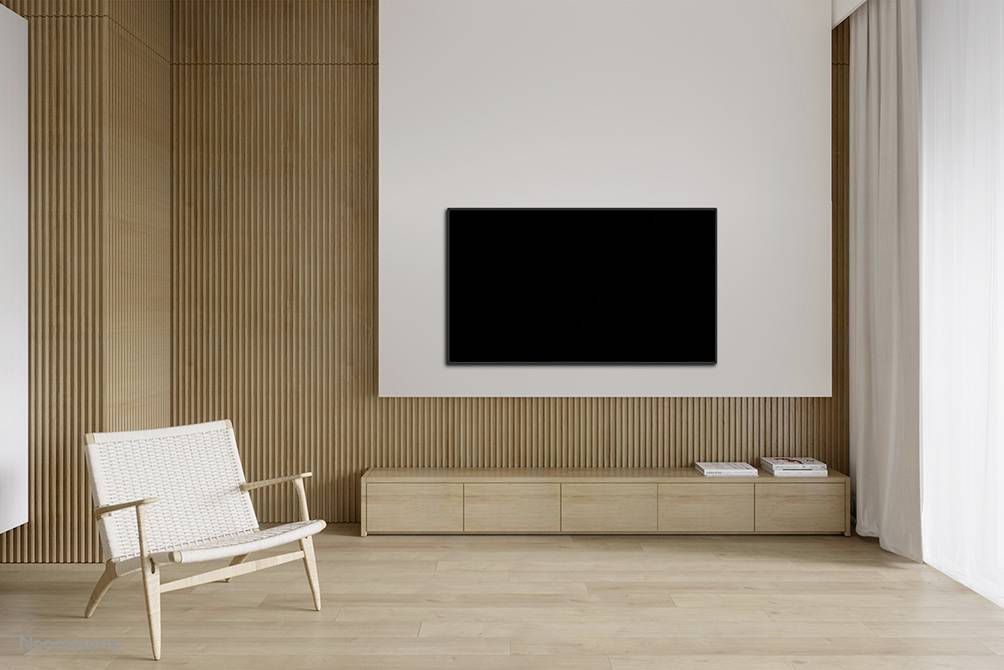 Modern minimalist room with a flat-screen television mounted on wooden panelling, an armchair and a sideboard.