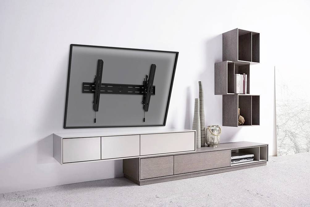 Television mount on the wall beside modern shelving, suitable for living room decor.