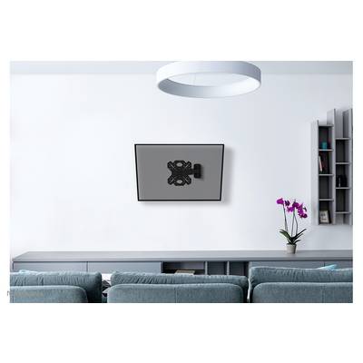 Living room with blue sofas, grey shelves and a wall-mounted flatscreen television. An orchid sits on the shelf.