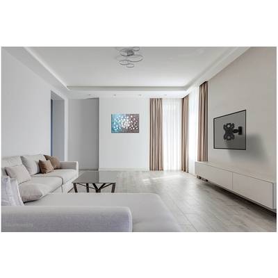 Bright living room with light-coloured furniture and wooden flooring. A large television mounted on the wall, with a modern abstract artwork beside it.