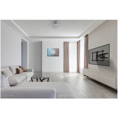 Modern living room with a grey sofa, glass coffee table, wall art, light curtains, and a wall-mounted TV. Bright and spacious atmosphere.