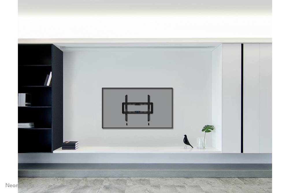 Television mounted on a wall, flanked by a black shelving unit on the left and a decorative bird figurine on the right, placed on a white surface.