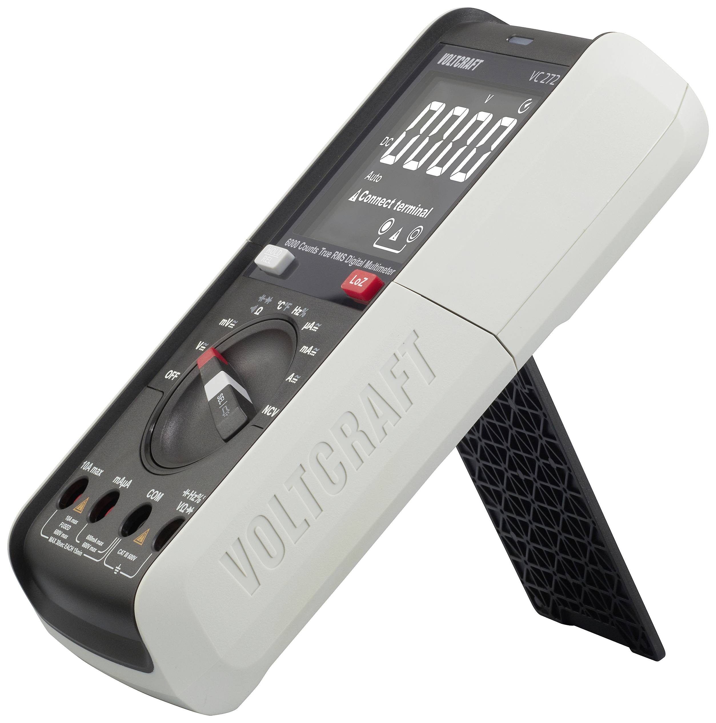 A digital multimeter 'Voltcraft VC270', standing on a support, displays electrical measurement values on a screen.