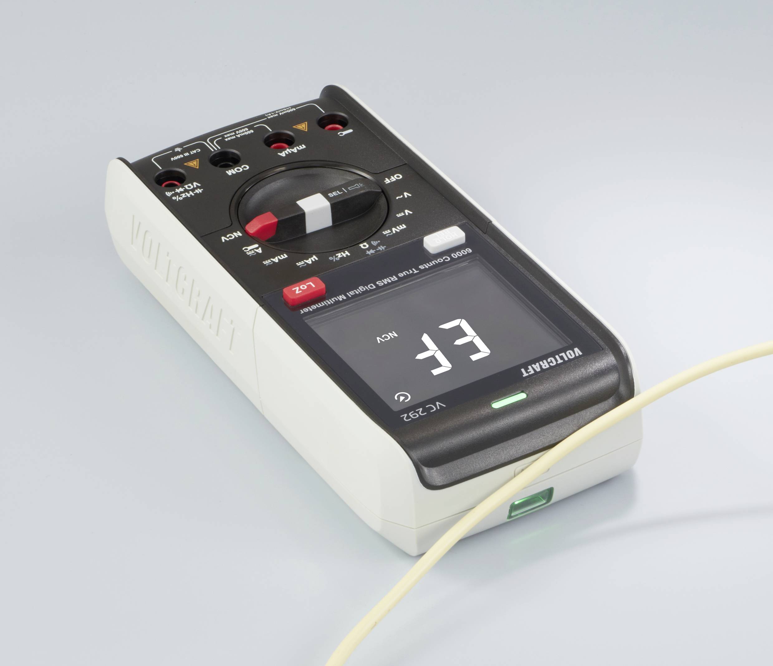 Digital multimeter in close-up on a light surface, showing 'EF' on the display. A cable is connected at the front.