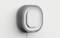 A square, modern thermostat with rounded corners mounted on the wall. It has a grey frame and a central display.