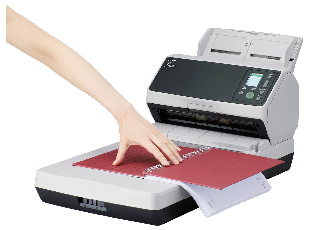 A scanner with an open lid scanning a red spiral-bound notebook, while a hand adjusts the pages.