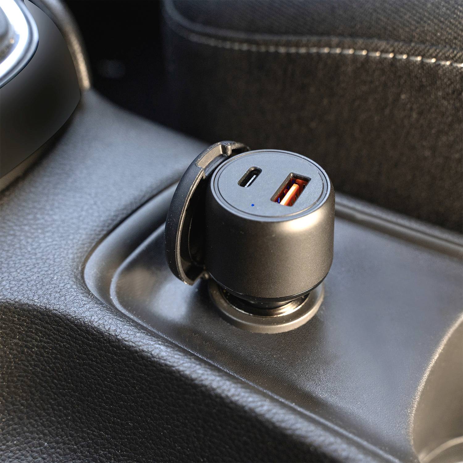 USB-A and USB-C charger in a car seat console, ready to charge.