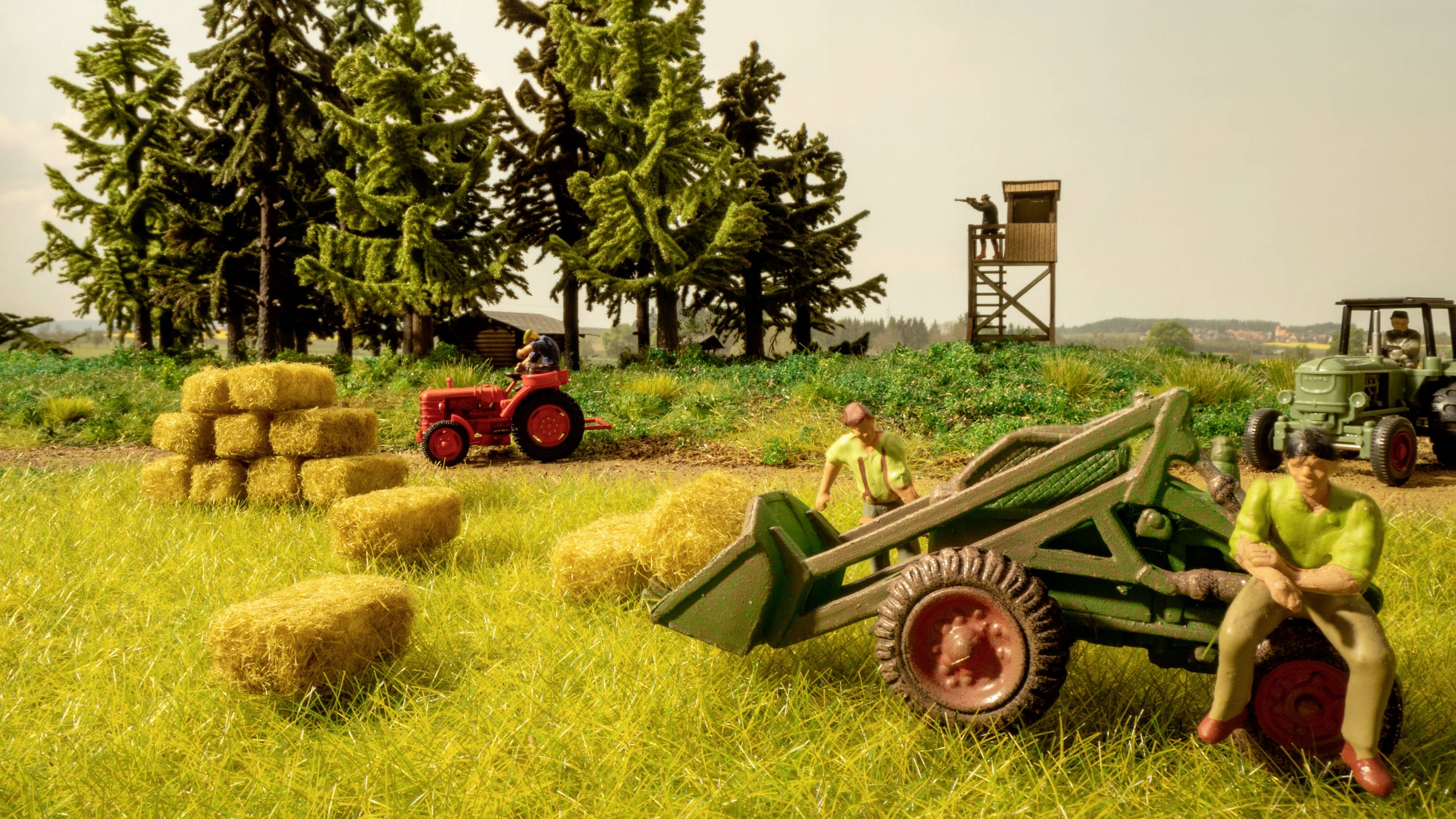 Farmers harvesting hay in a field with tractors and hay bales, surrounded by trees. A rural scene with agricultural machinery.