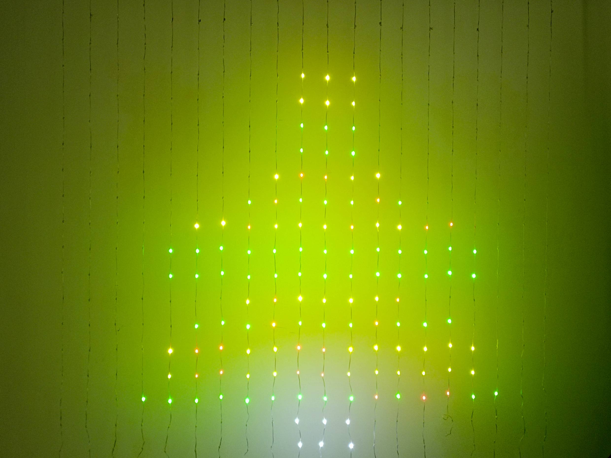 A large, luminous star-shaped form composed of green, yellow, and white lights glows on the wall.