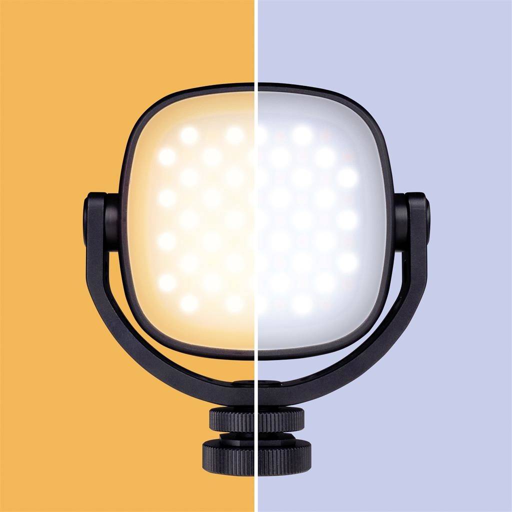 The image depicts an LED lamp, half illuminated with warm yellow light, half with cold blue light, against a two-toned background.