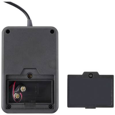 A black electronic device with an open battery compartment and removed cover, showing the battery contacts inside.
