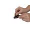 Two hands are holding a black and red ink pad. The right hand is pressing a round stamp onto it.