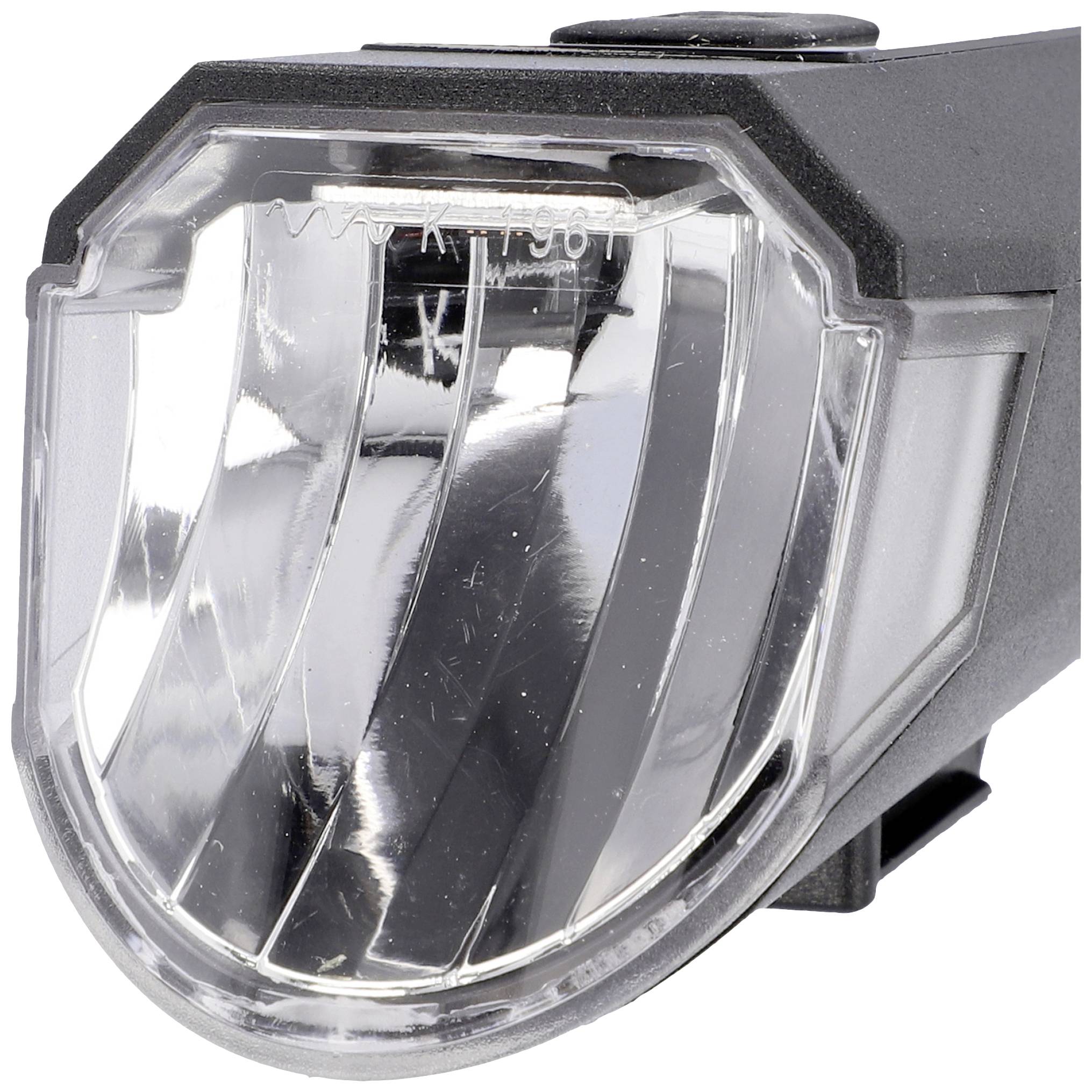 Close-up of a bicycle headlight with a transparent casing; suitable for dark or foggy conditions.