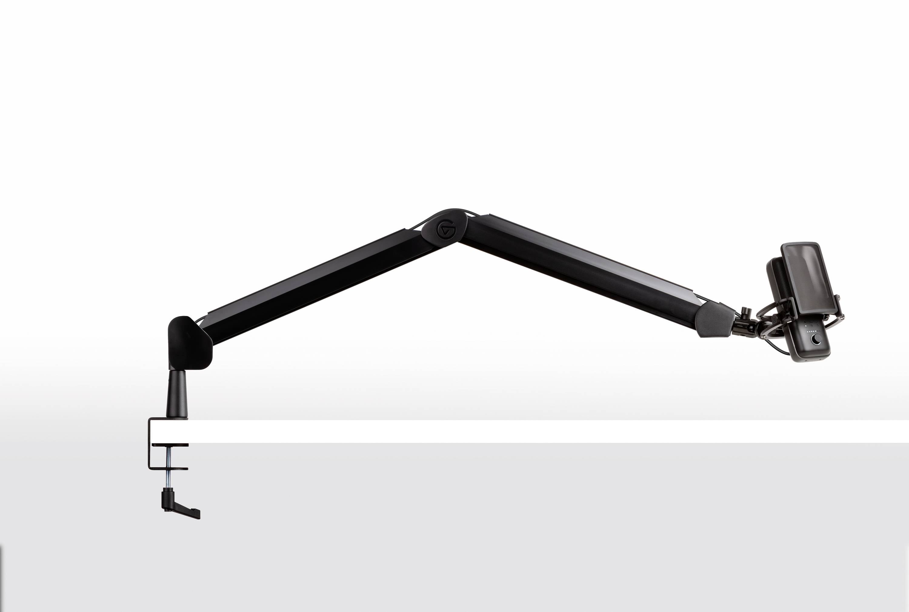 A black, elongated adjustable arm is attached to a table and holds a small device. The arm is flexible and can be repositioned with ease.