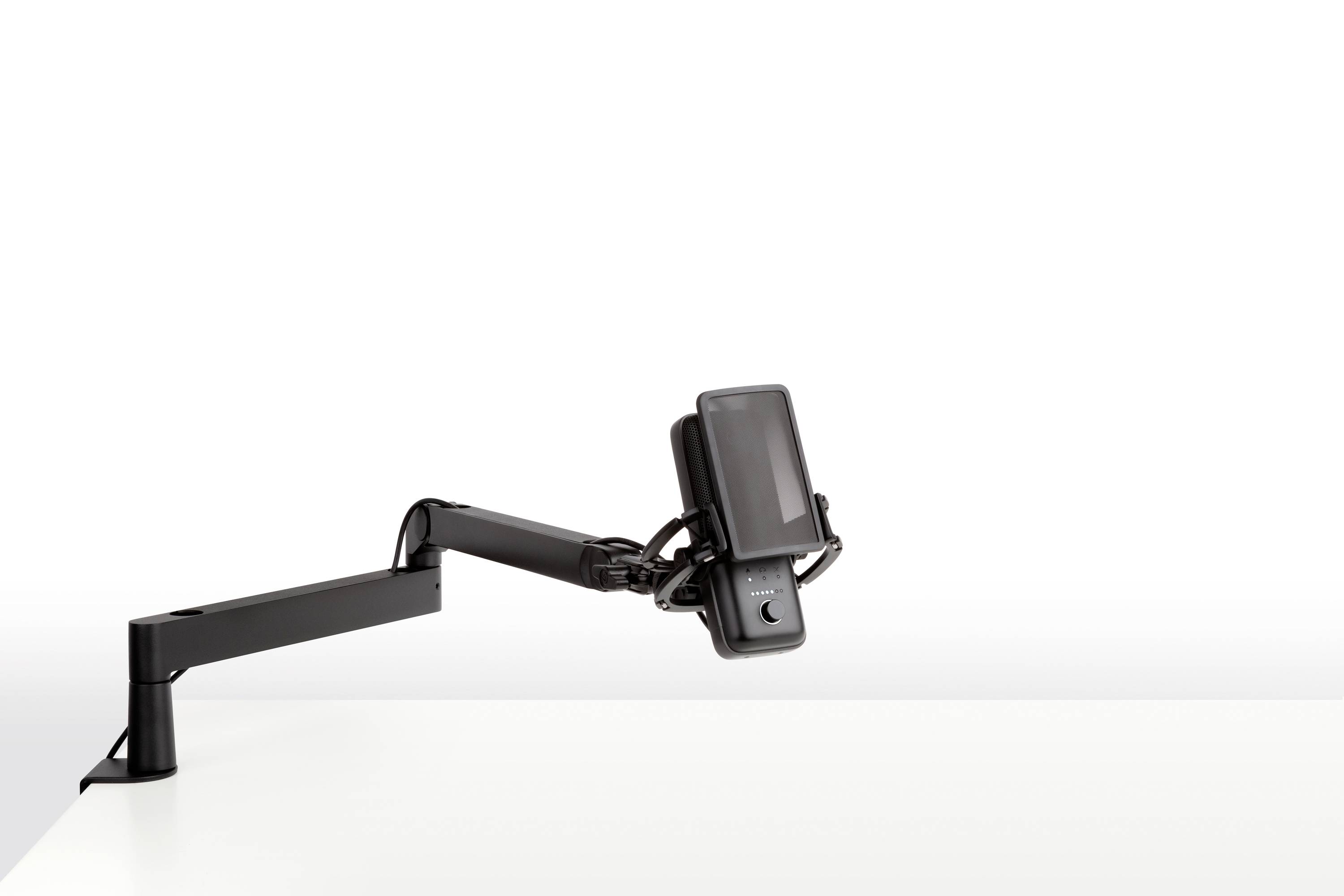 Black monitor arm, mounted on a white desk, with adjustable mounting bracket for screen. Minimalist, modern design.
