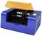 A blue laser cutter with an orange cover, partially open, reveals the cutting mechanism and control panel on the side.