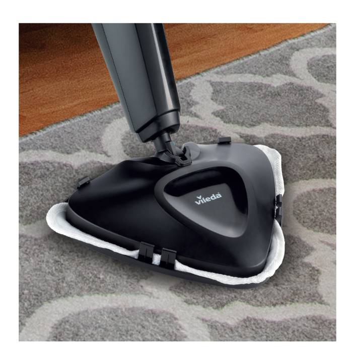 A steam cleaner glides over a carpet. The device is black, triangular and marked with 'Vileda'. It effectively cleans the carpet.