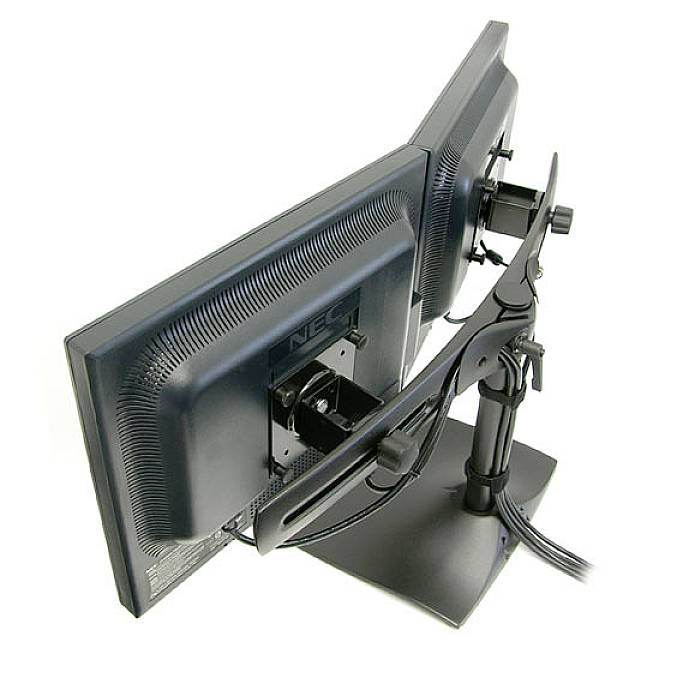 Two side-by-side mounted computer monitors on an adjustable stand, viewed from behind, showing cable management.