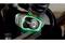 A person is holding an angle grinder working on a piece of metal. The grinder shows an illuminated gear through a transparent cover.