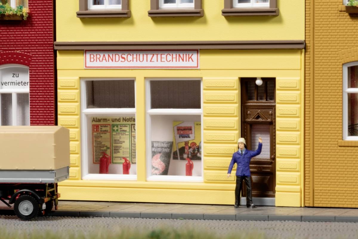 Fire protection technology business with a model lorry and a figure in a blue parka walking towards the door of the yellow building.