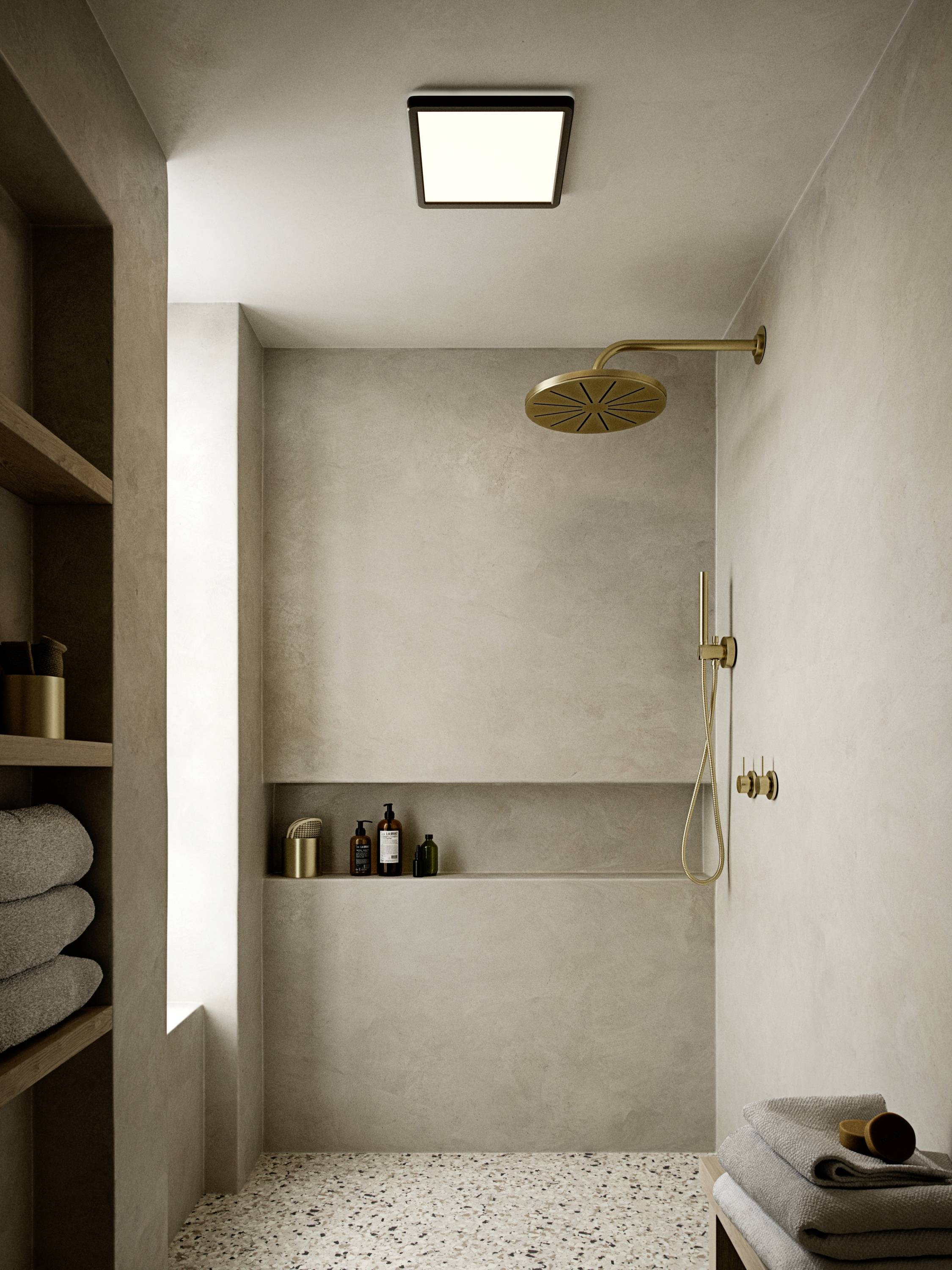 Elegant bathroom with minimalist design: rainfall shower, beige colour theme, niches with toiletries and towels.
