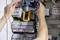 A person is testing electrical circuits in a fuse box with a multimeter. Many colourful cables are visible.