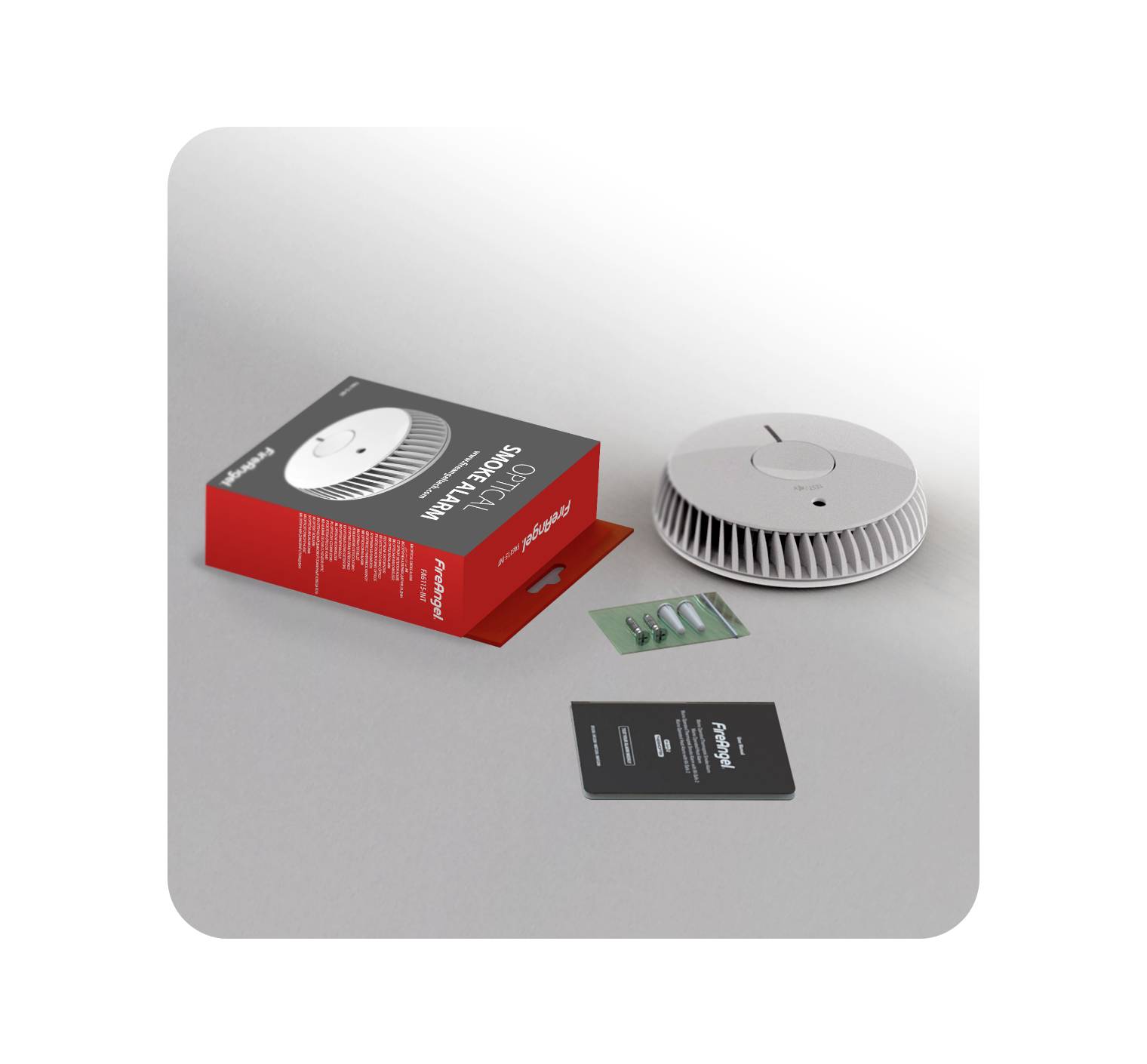 A smoke detector with packaging, instructions and batteries is lying on a table.