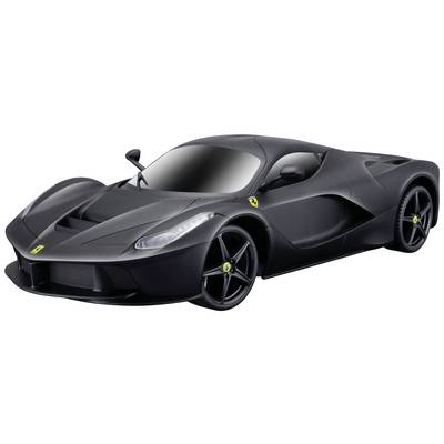 A black sports car with an aerodynamic design, sleek headlights and gleaming alloy wheels, positioned in a studio against a neutral background.
