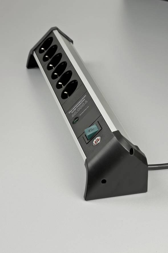 A black six-socket extension lead with a green on/off switch. It is resting on a grey surface.