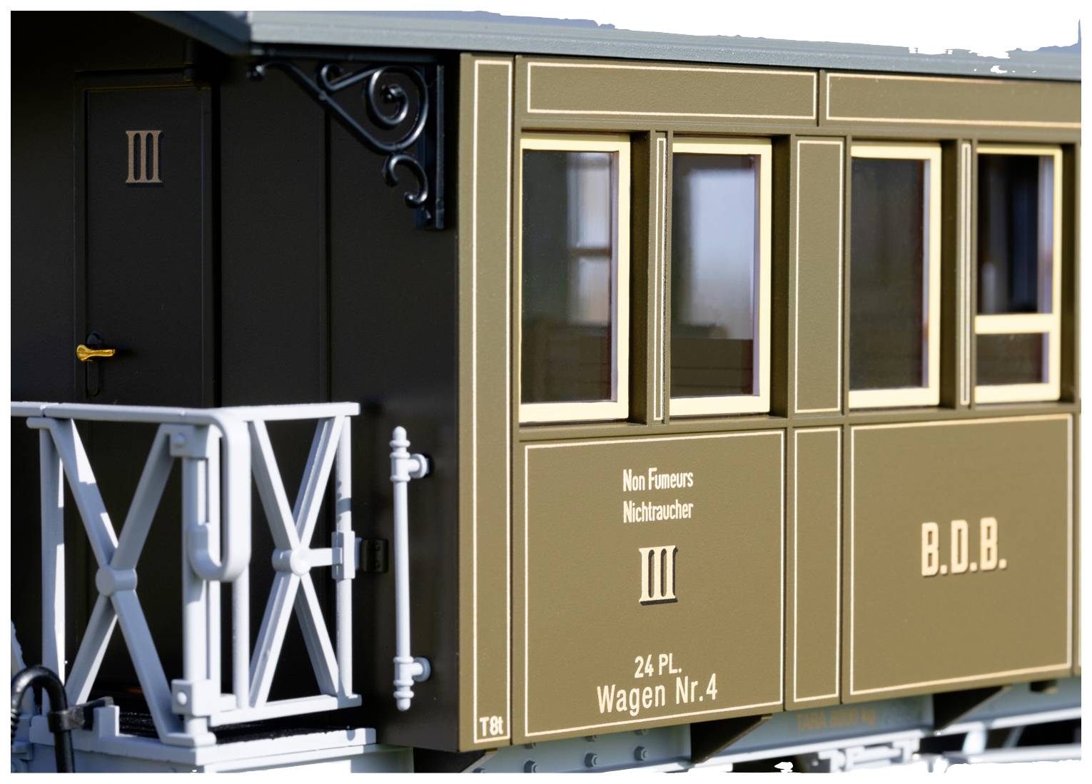 Older train carriage, brown painted, with inscriptions 'Non-Smoking', '24 Pl. Carriage No. 4', and 'B.D.B.', windows visible, architecturally detailed.